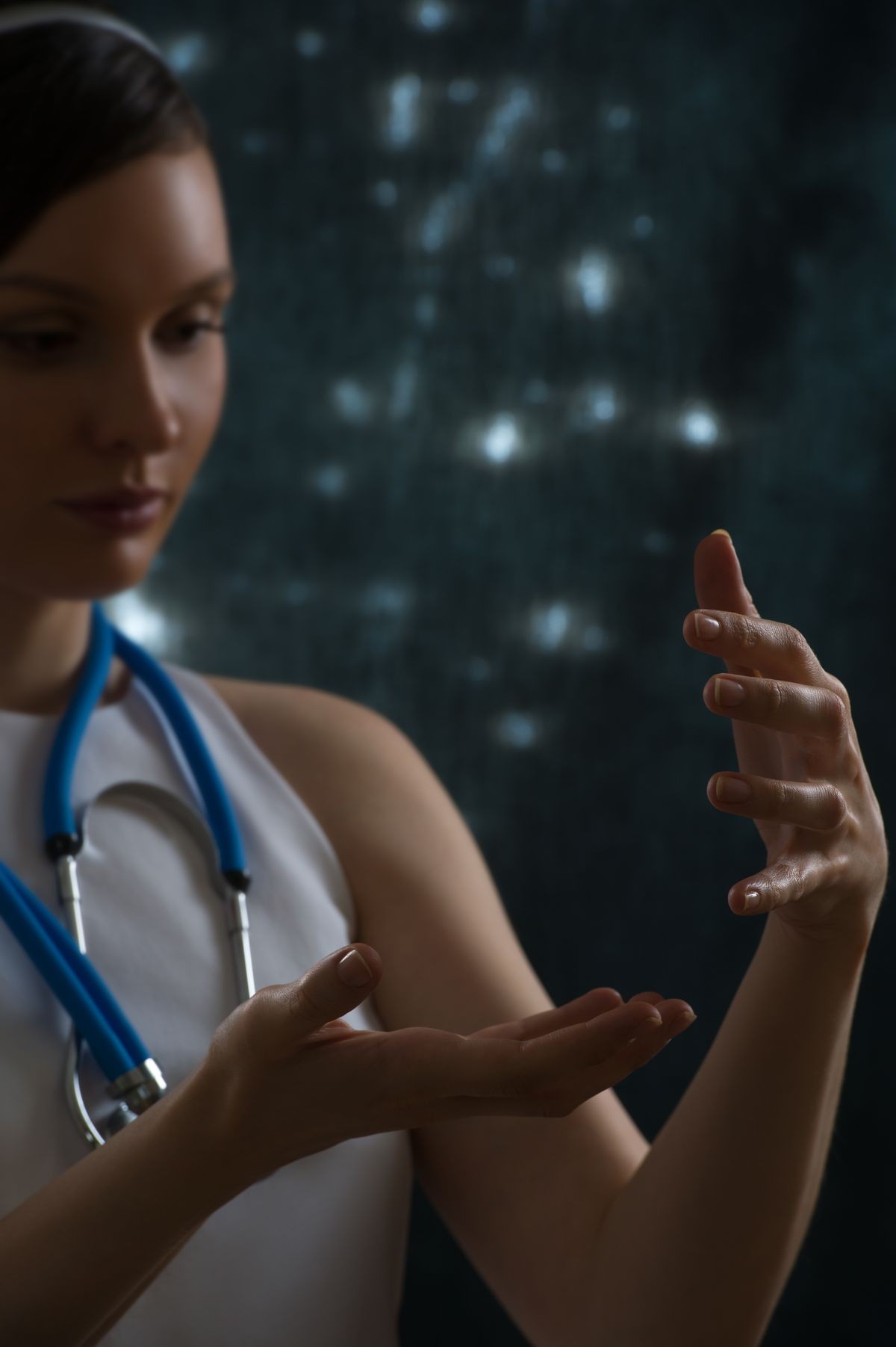 Pretty female doctor with stethoscope wearing futuristic clothes holding something in her hands